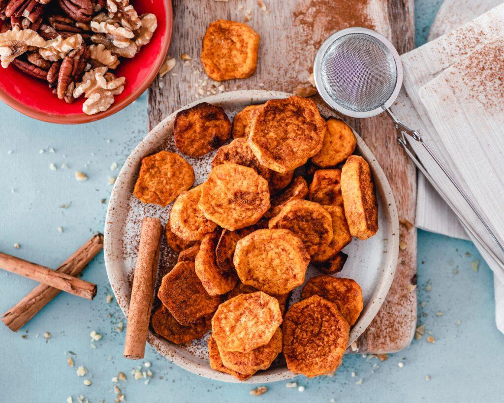 Baked sweet potato on a chopping board, sprinkled with cinnamon
