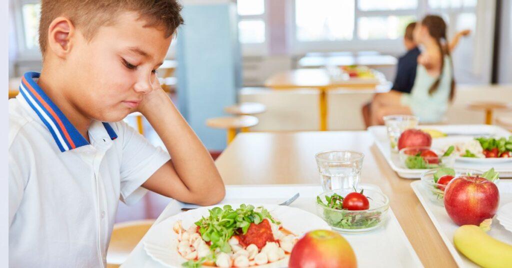 Child upset at school lunch table